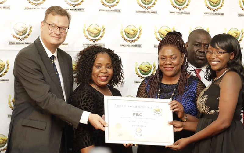 Faideth Foto (FBC Bank Operations Manager Convenience Banking- third from left), Sharon Tapesa (Call Centre CSO-second from left) and Laurinda Chiguvare (Call Centre Officer) receive the award from Dr Thorsten Hutter (German Ambassador to Zimbabwe-far left).
