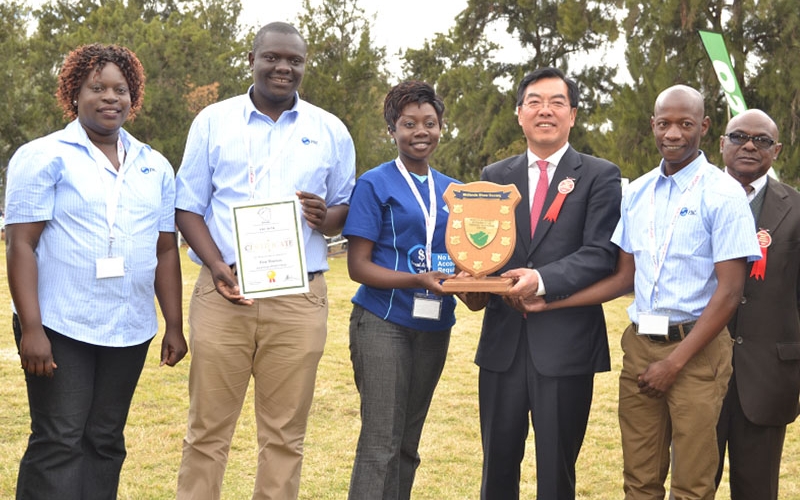 The FBC Team  led by Linda Nyambiya (Gweru Branch Manager- blue T-shirt) receive the best exhibitor award from the Chinese Ambassador to Zimbabwe, H.E Huang Ping