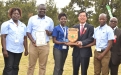 The FBC Team  led by Linda Nyambiya (Gweru Branch Manager- blue T-shirt) receive the best exhibitor award from the Chinese Ambassador to Zimbabwe, H.E Huang Ping